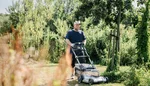 Marcel Matthieu mäht mit einem Rasenmäher eine Rasenfläche.